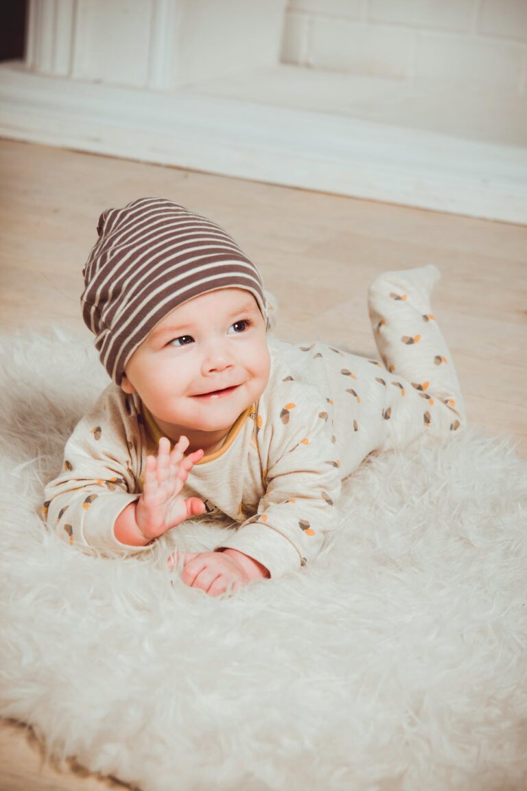 Smiling Baby Lying on White Mat